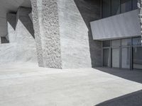 this is an outdoor courtyard with stone steps and a curved concrete wall, that stretches to the outside