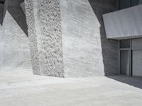 this is an outdoor courtyard with stone steps and a curved concrete wall, that stretches to the outside