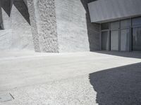 this is an outdoor courtyard with stone steps and a curved concrete wall, that stretches to the outside