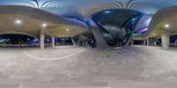 the panorama view of the entrance of a museum at night and showing the stairs and the curved roof