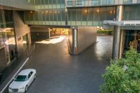 an overhead shot of a building with a car driving by it in the open air