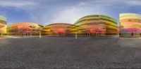 a very futuristic style building with lots of windows and colorful colored stripes on it's side