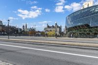 the big building is by the city street in the daytime and people walk on the sidewalk