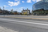 the big building is by the city street in the daytime and people walk on the sidewalk