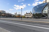 the big building is by the city street in the daytime and people walk on the sidewalk