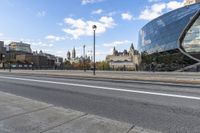 the big building is by the city street in the daytime and people walk on the sidewalk