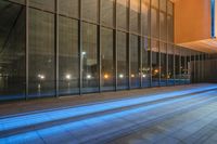 a long narrow road on the edge of a building with some blue lighting in it