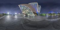 a panoramic view of the exterior of an opera performance space at night time