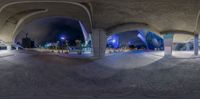 a fisheye shot is taken of a very small park with benches in it at night