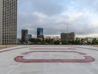 a paved courtyard on the top of a large building in the middle of the city