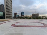 a paved courtyard on the top of a large building in the middle of the city