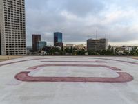 a paved courtyard on the top of a large building in the middle of the city