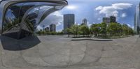 a reflection of the city and surrounding in a circular mirror mirror sculpture on the pavement