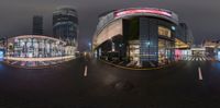 the image shows cars are passing through the street in the city at night time with long exposures