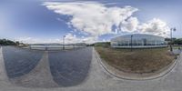 a wide angle photo of a street outside of an office building, as seen in a fisheye lens