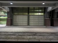 a garage with an open door and fire hydrant outside a building at night,