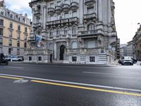 a picture of buildings and cars on a street in europe taken from the front seat seat