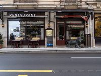 a street that has a restaurant sitting in front of it on a corner and some tables