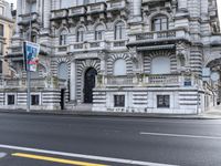 a black fire hydrant in the middle of a street in front of a large stone building