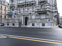 a black fire hydrant in the middle of a street in front of a large stone building