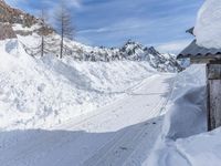 a person is skiing on a snowy hill side trail next to a lodge in winter
