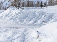 there is snow piled on the slope to make it difficult for people to ski down