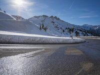 a snow covered hill in the mountains with skis hanging on it's sides