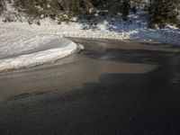 a road surrounded by snow covered trees on a sunny day with blue sky above in the background