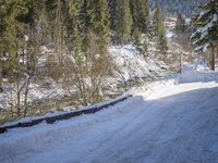 a snow boarder is riding down the snow - covered road in the mountains outside