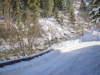a snow boarder is riding down the snow - covered road in the mountains outside