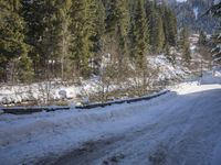 a snow boarder is riding down the snow - covered road in the mountains outside