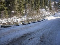 a snow boarder is riding down the snow - covered road in the mountains outside