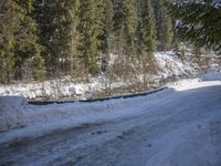 a snow boarder is riding down the snow - covered road in the mountains outside