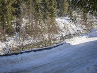 a snow boarder is riding down the snow - covered road in the mountains outside