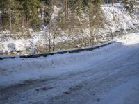 a snow boarder is riding down the snow - covered road in the mountains outside