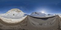 an upside down photo of snow and rocks in the air with snow and mountains around it