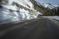 an abstract photograph of a speeding car on a snowy hill road while snow drifts the walls and mountains