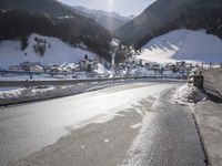 a mountain village with many houses covered in snow and surrounded by mountains and trees, snow is on the ground