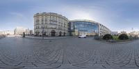 a circular fisheye photograph taken on an empty street with buildings in the background and a sky