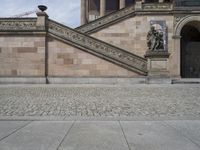 a person is standing on a walkway with an umbrella over their head looking towards the stairs