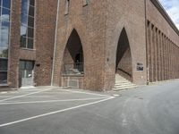 the corner of an industrial building with arches over it and two steps in front of the building