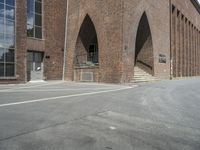 the corner of an industrial building with arches over it and two steps in front of the building