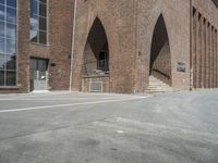 the corner of an industrial building with arches over it and two steps in front of the building