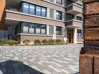 a brick wall sitting in front of a building with a clock on it's outside