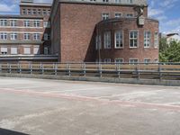 there is a man riding a bike in a parking lot next to buildings on a bridge