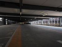 an empty parking lot with a car park underneath the structure above the garage and a few cars parked along the road