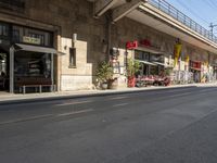 an old stone building next to a sidewalk with a traffic light in front of it