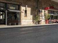 an old stone building next to a sidewalk with a traffic light in front of it