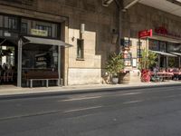 an old stone building next to a sidewalk with a traffic light in front of it