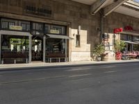 an old stone building next to a sidewalk with a traffic light in front of it